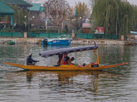 Indian tourists take the Uber ''Shikara'' or small boat ride after Uber launches its first water transport service on the waters of Dal Lake...