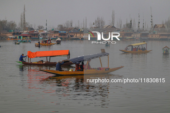 Indian tourists take the Uber ''Shikara'' or small boat ride after Uber launches its first water transport service on the waters of Dal Lake...