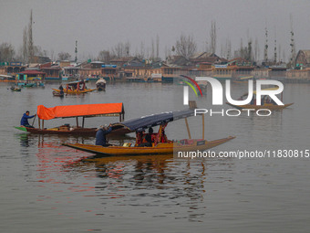 Indian tourists take the Uber ''Shikara'' or small boat ride after Uber launches its first water transport service on the waters of Dal Lake...