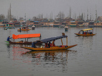 Indian tourists take the Uber ''Shikara'' or small boat ride after Uber launches its first water transport service on the waters of Dal Lake...