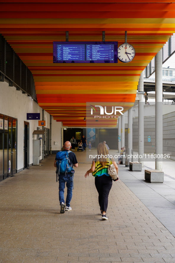 Passengers check departures at Ludwigsburg Station in Germany on July 1, 2023. Travelers of all ages pass beneath the digital timetable disp...