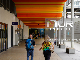 Passengers check departures at Ludwigsburg Station in Germany on July 1, 2023. Travelers of all ages pass beneath the digital timetable disp...