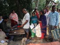 People receive rations under the ''Duare Ration'' (Ration at the doorstep) scheme at a temporary camp in Jayanagar village on the outskirts...