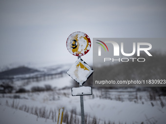 A traffic sign is partially covered by snow on Route 1 (Ring Road) on the way to the town of Blonduos in Iceland on November 27, 2024. Roads...