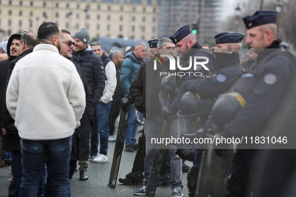 French Republicain Security Corps (CRS) officers face taxi drivers at the Invalides during a protest against lower mileage rates for patient...