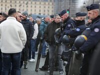 French Republicain Security Corps (CRS) officers face taxi drivers at the Invalides during a protest against lower mileage rates for patient...