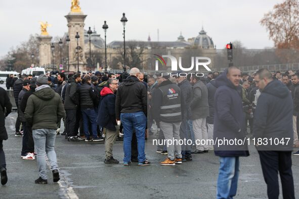 Taxi drivers gather at the Invalides during a protest against lower mileage rates for medical patient transport in Paris, France, on Decembe...