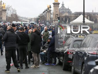 Taxi drivers gather at the Invalides during a protest against lower mileage rates for medical patient transport in Paris, France, on Decembe...