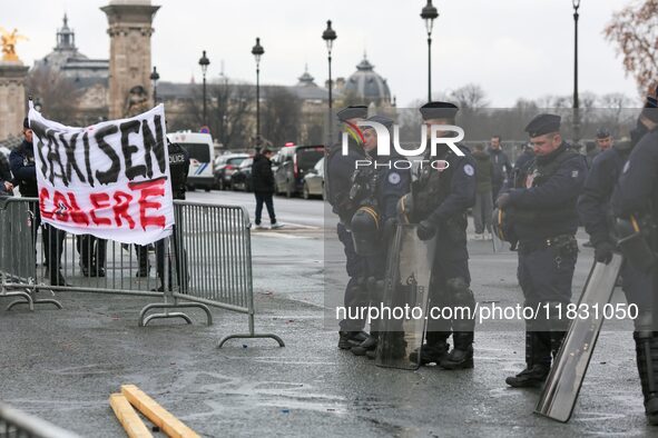 French Republicain Security Corps (CRS) officers face taxi drivers at the Invalides during a protest against lower mileage rates for patient...