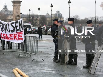 French Republicain Security Corps (CRS) officers face taxi drivers at the Invalides during a protest against lower mileage rates for patient...