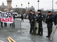 French Republicain Security Corps (CRS) officers face taxi drivers at the Invalides during a protest against lower mileage rates for patient...