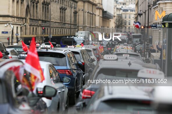 Taxi drivers gather at the Invalides, in front of the Assemblee nationale, during a protest against lower mileage rates for medical patient...