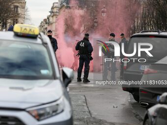 Taxi drivers wave smoke bombs at the Invalides during a protest against lower mileage rates for patient transport in Paris, France, on Decem...