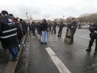 French Republicain Security Corps (CRS) officers face taxi drivers at the Invalides during a protest against lower mileage rates for patient...