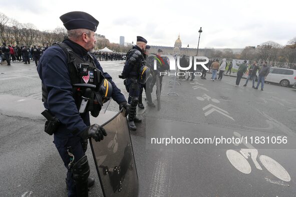 French Republicain Security Corps (CRS) officers face taxi drivers at the Invalides during a protest against lower mileage rates for patient...