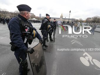 French Republicain Security Corps (CRS) officers face taxi drivers at the Invalides during a protest against lower mileage rates for patient...