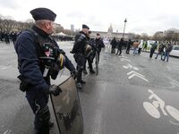 French Republicain Security Corps (CRS) officers face taxi drivers at the Invalides during a protest against lower mileage rates for patient...