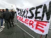 Taxi drivers display a banner reading ''taxi drivers in anger'' at the Invalides during a protest against lower mileage rates for patient tr...