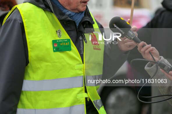 A retiree speaks with the press during a rally by retired people to call for pensions to be raised with inflation in Paris, France, on Decem...