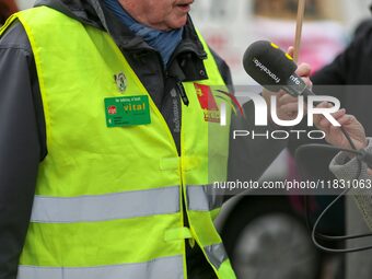 A retiree speaks with the press during a rally by retired people to call for pensions to be raised with inflation in Paris, France, on Decem...