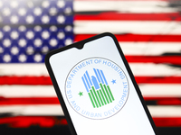 The United States Department of Housing and Urban Development (HUD) logo appears on the screen of a smartphone, and in the background, the f...