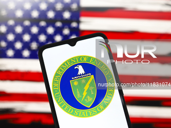 The United States Department of Energy (DOE) logo appears on the screen of a smartphone, and in the background, the flag of the United State...