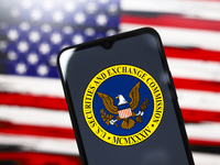 The United States Securities and Exchange Commission (SEC) logo appears on the screen of a smartphone, and in the background, the flag of th...