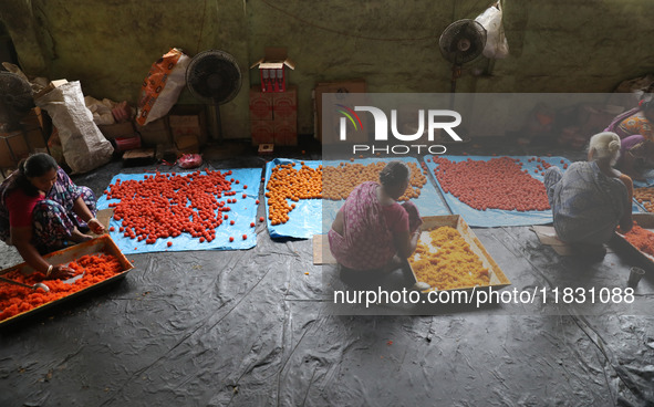 Workers prepare ''Laddu,'' a ball-shaped sweet, inside a workshop for sale in the wholesale market in Jayanagar village on the outskirts of...