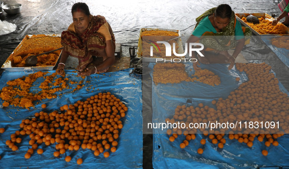 Workers prepare ''Laddu,'' a ball-shaped sweet, inside a workshop for sale in the wholesale market in Jayanagar village on the outskirts of...