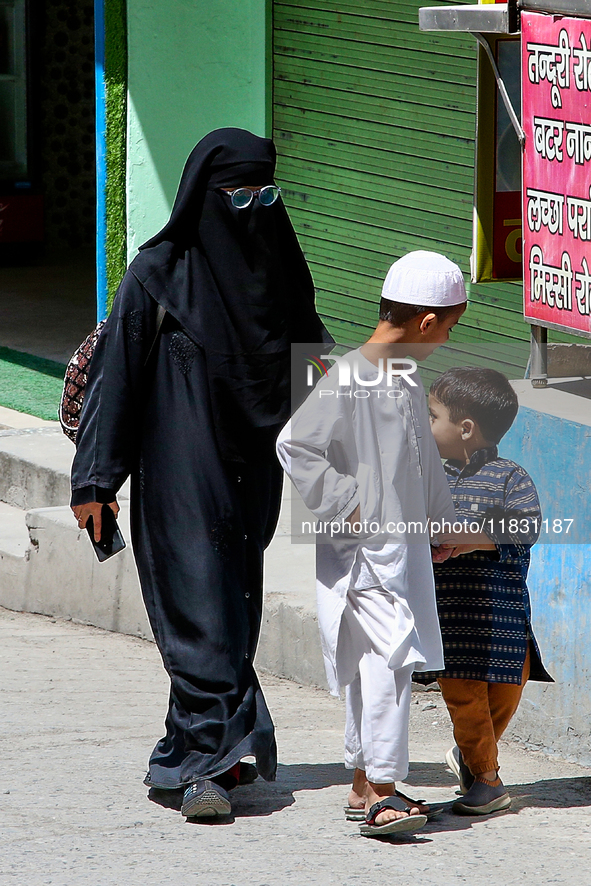 A Muslim woman and her two children walk along a street in Mussoorie, Uttarakhand, India, on April 18, 2024. 