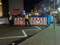 Several security workers reinstall the barriers at the closed Bochum Christmas market in Bochum, Germany, on December 3, 2024, as several la...