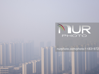 Buildings loom in the morning fog in Ningbo, Zhejiang province, China, on December 3, 2024. (