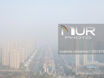 Buildings loom in the morning fog in Ningbo, Zhejiang province, China, on December 3, 2024. (