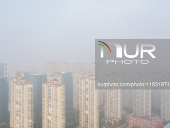 Buildings loom in the morning fog in Ningbo, Zhejiang province, China, on December 3, 2024. (