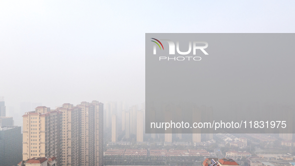 Buildings loom in the morning fog in Ningbo, Zhejiang province, China, on December 3, 2024. 