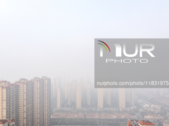 Buildings loom in the morning fog in Ningbo, Zhejiang province, China, on December 3, 2024. (