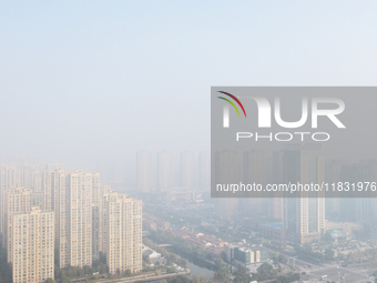 Buildings loom in the morning fog in Ningbo, Zhejiang province, China, on December 3, 2024. (