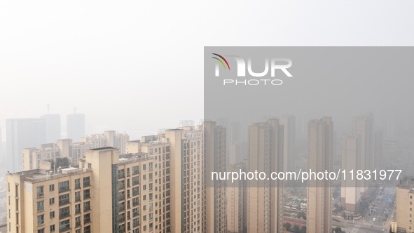 Buildings loom in the morning fog in Ningbo, Zhejiang province, China, on December 3, 2024. 