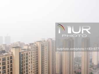 Buildings loom in the morning fog in Ningbo, Zhejiang province, China, on December 3, 2024. (