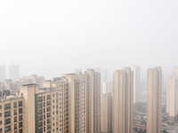 Buildings loom in the morning fog in Ningbo, Zhejiang province, China, on December 3, 2024. (