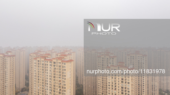 Buildings loom in the morning fog in Ningbo, Zhejiang province, China, on December 3, 2024. 