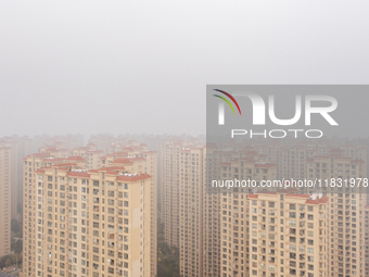 Buildings loom in the morning fog in Ningbo, Zhejiang province, China, on December 3, 2024. (