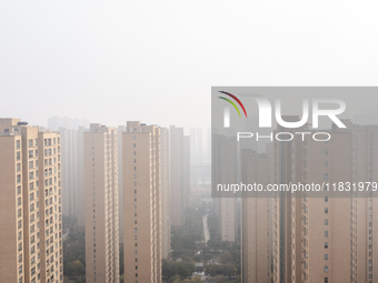 Buildings loom in the morning fog in Ningbo, Zhejiang province, China, on December 3, 2024. (