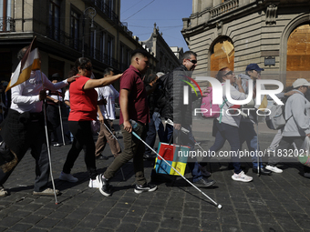 People with disabilities demonstrate on the occasion of the International Day of Persons with Disabilities, marching on Avenida Juarez to th...