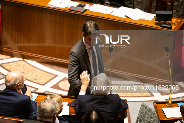 Former French Prime Minister Gabriel Attal shakes hands with Michel Barnier, French Prime Minister, during the questions to the National Ass...