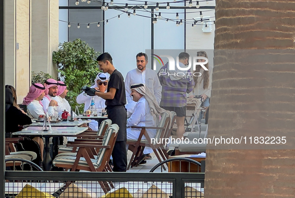 People sit outside a cafe in Downtown in the afternoon in Doha, Qatar, on December 03, 2024. 