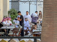 People sit outside a cafe in Downtown in the afternoon in Doha, Qatar, on December 03, 2024. (