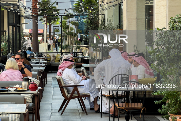 People sit outside a cafe in Downtown in the afternoon in Doha, Qatar, on December 03, 2024. 