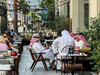 People sit outside a cafe in Downtown in the afternoon in Doha, Qatar, on December 03, 2024. (