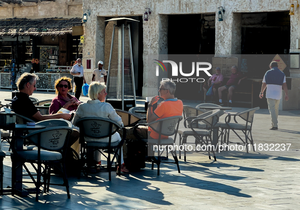 People sit outside a cafe in Downtown in the afternoon in Doha, Qatar, on December 03, 2024. 